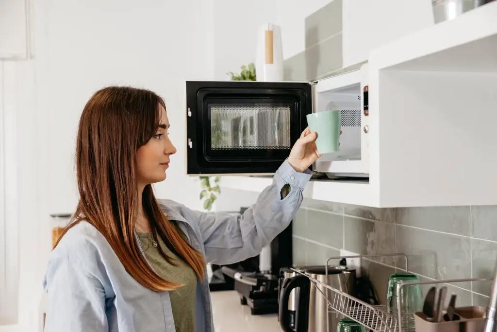 women in kitchen with microwave oven